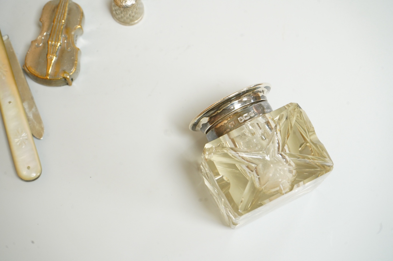 A small group of silver and other items, including an Edwardian silver mounted Common Prayer book(a.f.), a silver mounted matches holder, a silver mounted glass inkwell, a silver and mother of pearl fruit knife, two thim